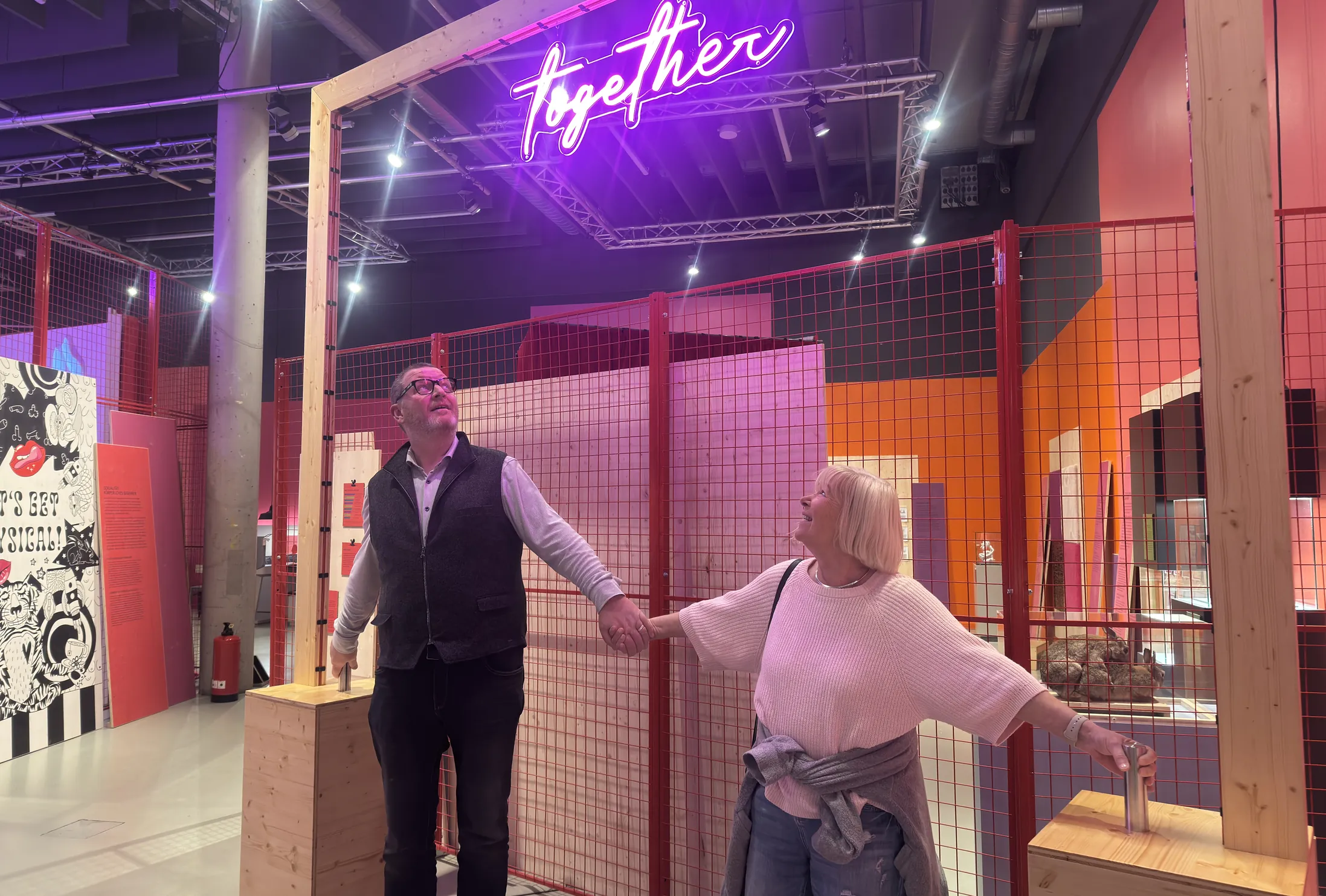 Zwei Besucher probieren das together-Exponat in der Ausstellung LIEBE aus