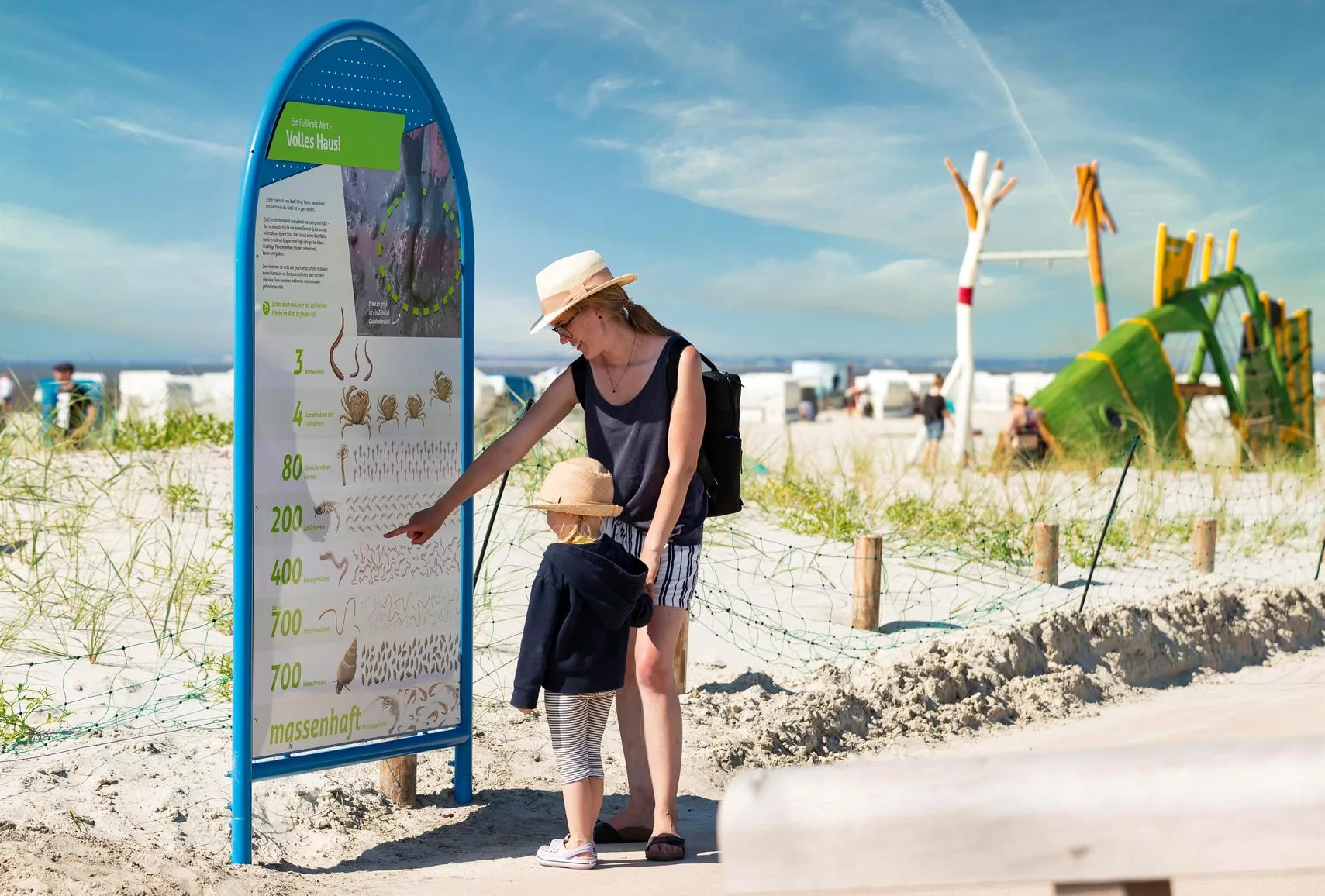 Familie an einer interaktiven Station des Erlebnispfads am Wattenmeer in Norddeich